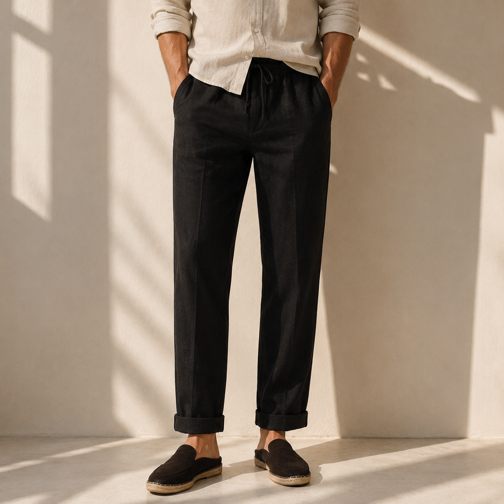 Model wearing men's black linen drawstring trousers with rolled cuffs and espadrilles - Rivaro