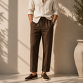 Model wearing men's brown linen drawstring trousers with natural beige shirt - Rivaro