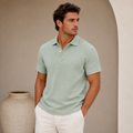 Model wearing men's sage green linen polo shirt paired with white trousers - Rivaro